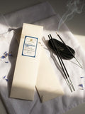Incense packaging with incense sticks on a light fabric background